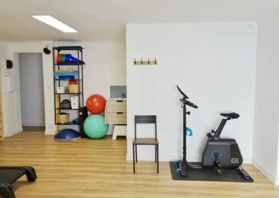 Cabinet avec un vélo d'intérieur, des ballons de gym et du matériel de kinésithérapie