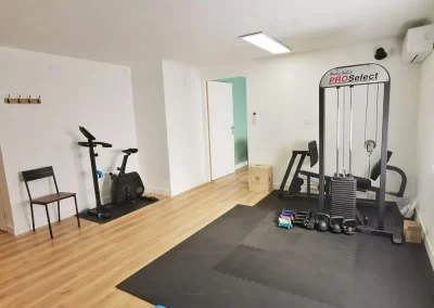 Un cabinet avec une presse de musculation et un vélo d'intérieur